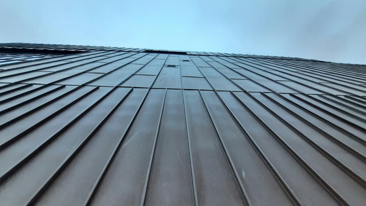 Close view of a standing-seam metal roof against the sky